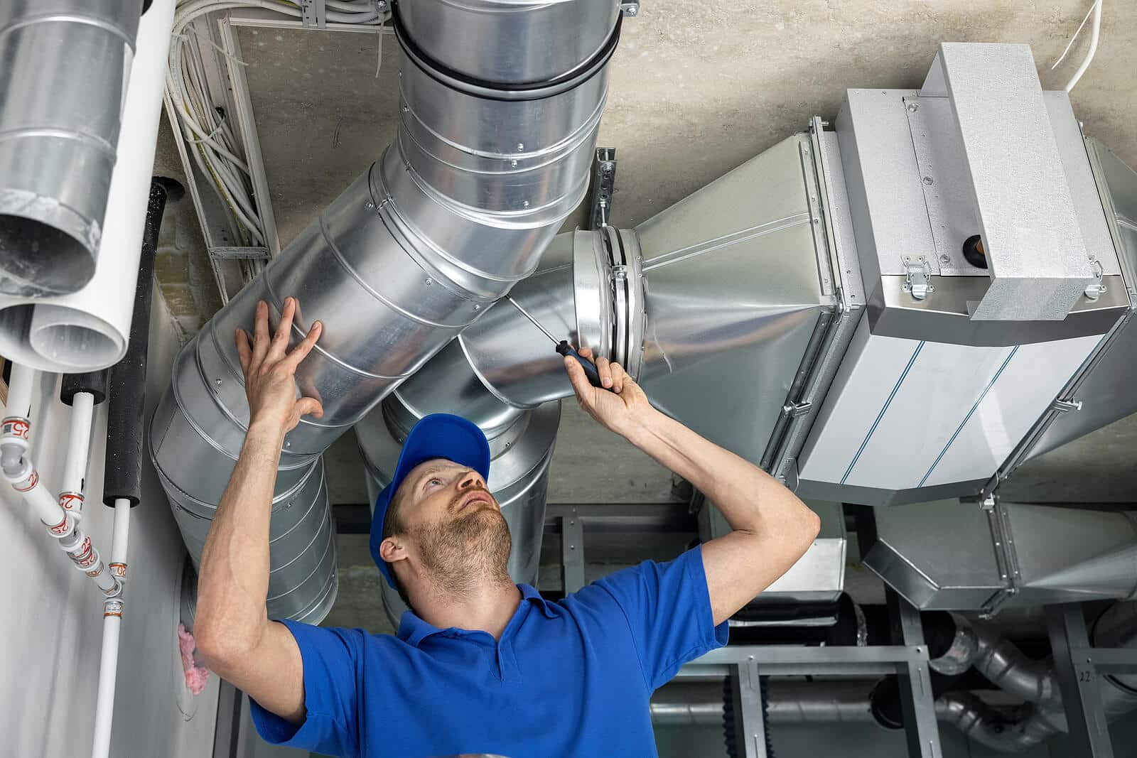 HVAC technician inspecting and repairing air ducts in Madera