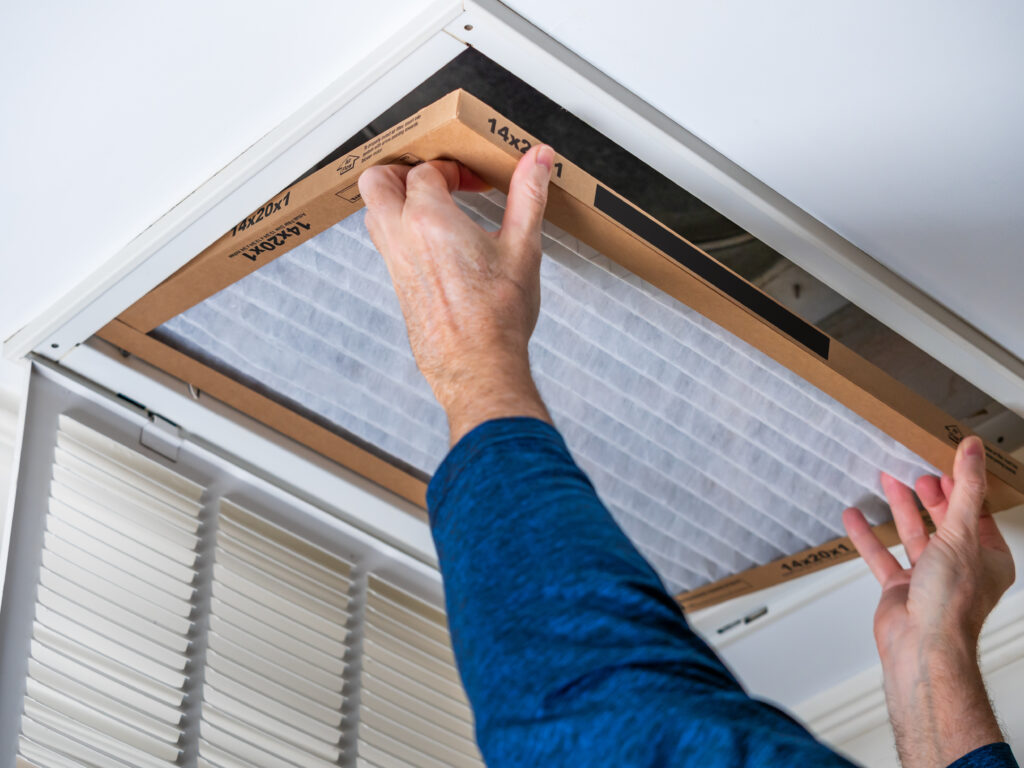HVAC technician replacing a home air filter in Madera