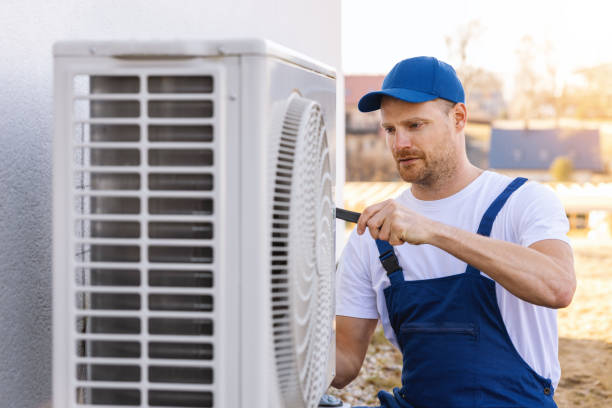 HVAC technician servicing an outdoor air conditioner in Madera